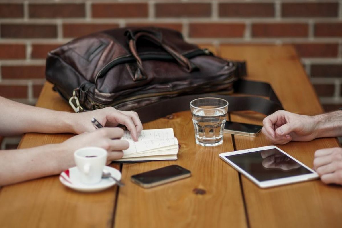 Chartered Accountants reviewing compliance documents across a meeting table